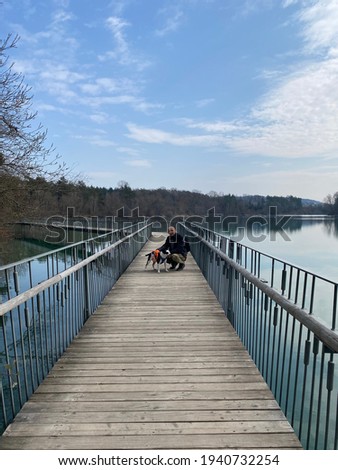Man with a dog on a bridge by lake salem