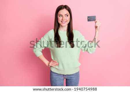 Photo of optimistic cute brunette girl show look card wear lime shirt jeans isolated on pink color background