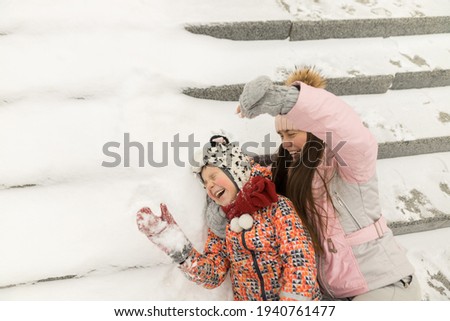 Close up of family sit on snowy steps and have a fun
