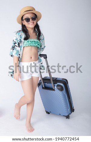 Children wearing hawaiian shirts traveler with suitcase and hat, sunglasses. little stylish girl in swimsuit, relaxing white background. lovely photo for advertising. beach vacation concept.