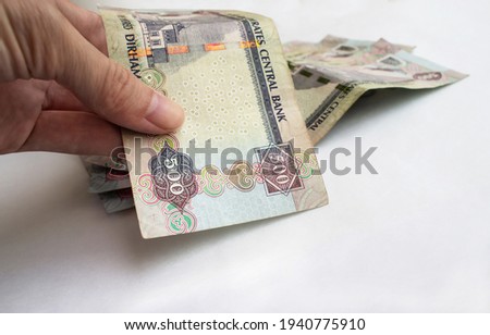 Hand holding 500 dirhams, United Arab Emirates (UAE) money, on a white background, closeup, paper money