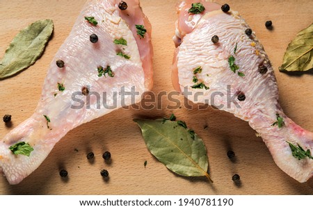 Сhicken legs on a cutting board with spices close-up. The idea of cooking lunch or breakfast in a restaurant