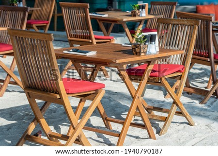 Wooden table and chairs in empty beach cafe next to sea. Close up. Island Koh Phangan, Thailand