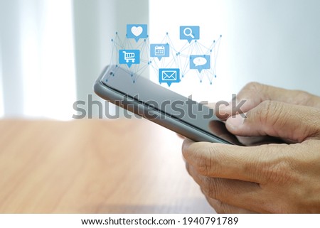 Social media interactions on smart mobile phone. Concept of notification icons of like, message, email and comment. Hands holding the device.