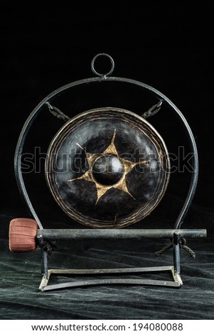 a small asian gong over a dark background