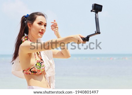 Beautiful Asian woman are happy and relaxed on their summer vacation, taking a walk and taking a selfie. At the beautiful beaches of Thailand