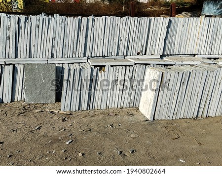 stock photo of large number of grey kota stone piled up on another for sale in bright sunlight at gulbarga karnataka India. focus on object.