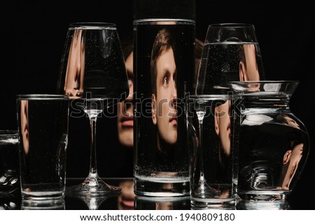 portrait of a man through the glass of the tank with water with the reflections