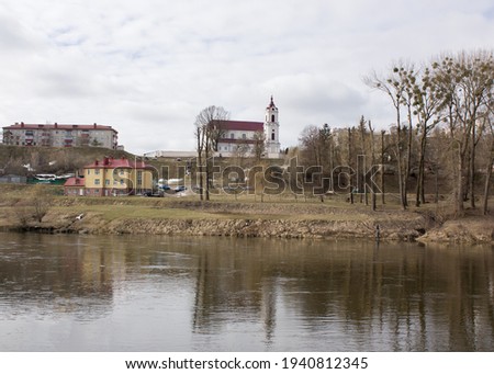 Grodno. Belarus. Spring landscape with the Neman river, with an old catholic church and houses on a hilly bank.