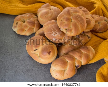 Homemade bread on yellow kitchen towel. Top view photo of freshly backed pastry items.  Gray textured background. 