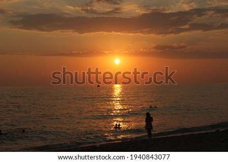 Young girl walking by the sea and sunset