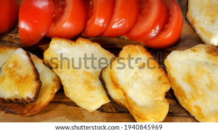 breakfast with fried halloumi cheese and tomatoes on a wooden stand