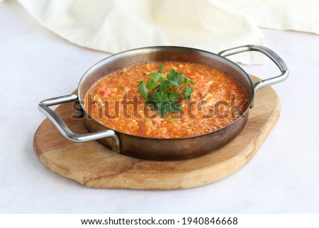 Tomato and peppered egg on wooden background. Local name menemen Royalty-Free Stock Photo #1940846668