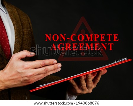 Non compete agreement or clause in the red folder. Royalty-Free Stock Photo #1940868076