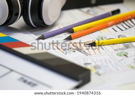Storyboard Video for Pre-production on film movie concept: Color pencil drawing on sketch board cartoon template with headphone on slate, Behind process design creative scene in studio