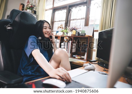 Stay at home office lifestyle concept. Happy smile young adult freelancer asian woman wear headset in workplace space with window light on day. Still life with modern digital online media.