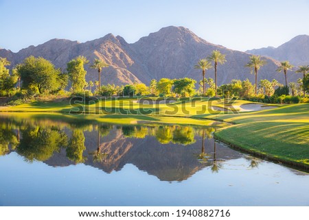 Beautiful golden light over Indian Wells Golf Resort, a desert golf course in Palm Springs, California, USA with view of the San Bernardino Mountains. Royalty-Free Stock Photo #1940882716