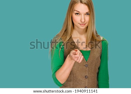 Smiling young woman showing cash gesture on turkish blue background