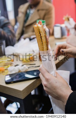 man holding a sandwich in his hand in a restaurant