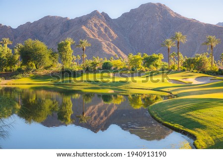 Beautiful golden light over Indian Wells Golf Resort, a desert golf course in Palm Springs, California, USA with view of the San Bernardino Mountains. Royalty-Free Stock Photo #1940913190