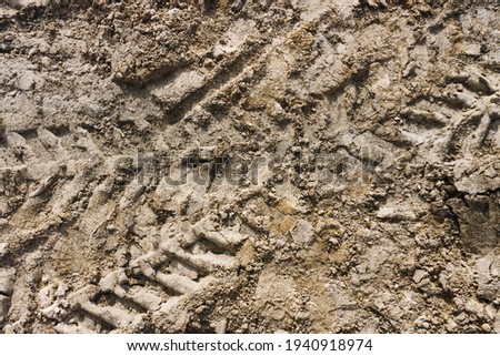 Tyre mark background. Tire track shape. Trail lines on dry brown sand pattern. Construction site road backdrop. Heavy machinery imprint. Dried mud vehicle wheel shape.
