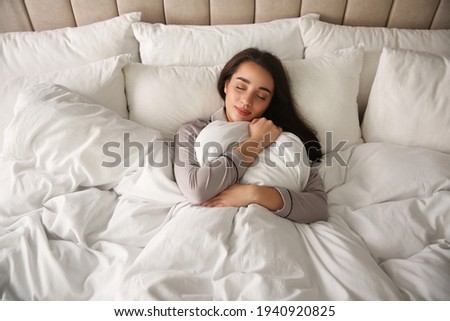 Beautiful young woman wrapped with soft blanket sleeping in bed at home, above view Royalty-Free Stock Photo #1940920825