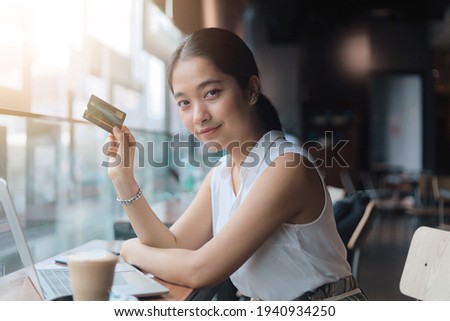 Portrait Asian woman holding credit card in cafe,Businesswoman working at cafe ,Woman with credit card Online shopping, internet banking, spending money, work from home concept.