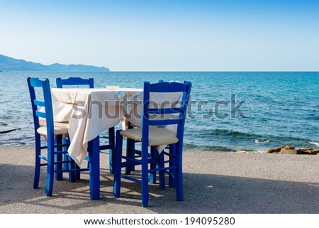 Table and chairs in sidewalk cafe at Kissamos, Crete, Greece  Royalty-Free Stock Photo #194095280