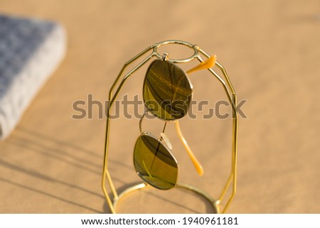 Classic sunglasses model with golden lenses shoot outside in a sunny day closeup . Selective focus