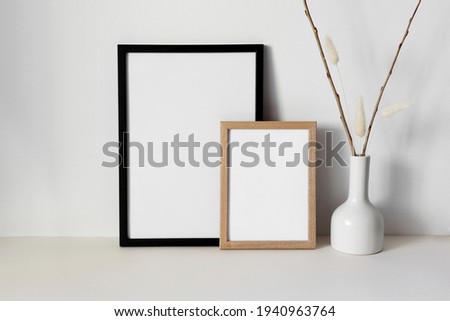 Two frame with white vase on white wall
