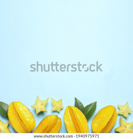 Delicious carambola fruits on light blue background, flat lay. Space for text