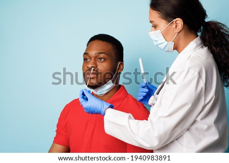 Doctor Making Covid-19 PCR Test For Male Patient, Blue Background