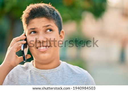 Adorable latin boy smiling happy talking on the smartphone at the city.