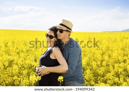 Spring outdoor portrait of young pregnant couple
