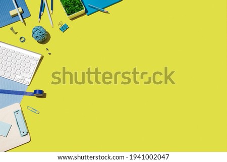Top view of worktable with office and school accessories. Business flat lay, green background.