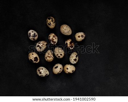 Geometric shapes from quail eggs on a black textured background. Scattering