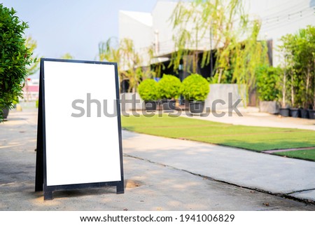 Blank white signboard stand on the storefront. Blank business billboard on an urban sidewalk