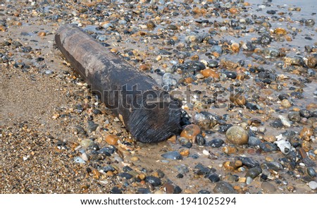 A large round piece of wood washed up at a North Nrfolk beach