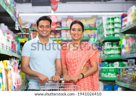 Portrait of indian couple at grocery store while shopping. Royalty-Free Stock Photo #1941026410