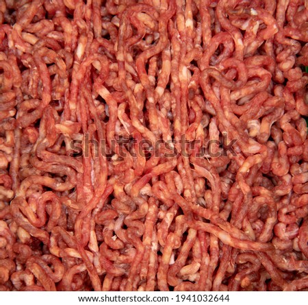 Full frame fresh raw minced meat as a backdrop.