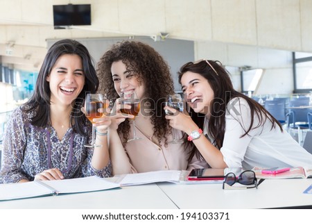 Group of happy students preparing their exams or simply relaxing at a bar