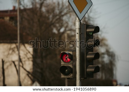 A selective focus shot of traffic lights with the sign of the main road 