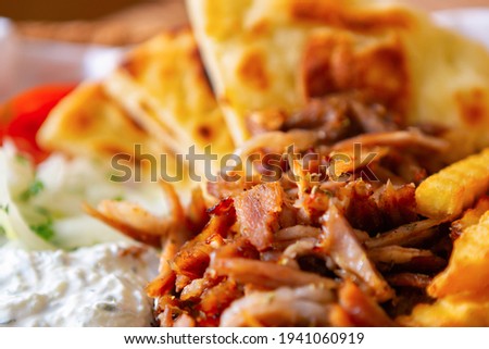Greek street food meal with kebab meat, pita bread and white youghurt served in fastfood restaurant for takeaway.Download royalty free curated images collection with foods for design template