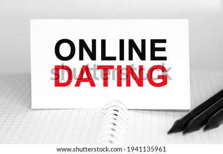 Text ONLINE DATING on paper card, Pencils on table - business, banking, finance and investment concept.