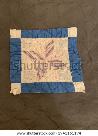 Distressed old quilt block in star design with holes and batting showing