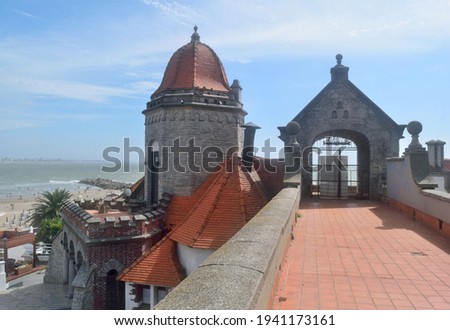 Photography of an ancient building known as Monk's Turret (Torreón del Monje) at Mar del Plata City whit the beach, the sea, a pier and the skyline in the background
