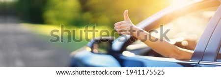 Woman inside her car gesticulate thumb up Royalty-Free Stock Photo #1941175525