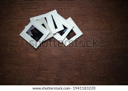 Old white paper slides with photographic film on a wooden table