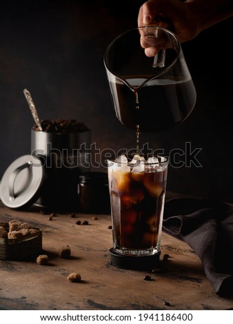 Cold coffee with cream on a dark background Royalty-Free Stock Photo #1941186400