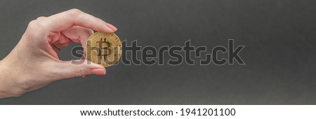 bitcoin in hand, female hand holds a gold bitcoin coin. Cryptocurrency value, digital money, space for text